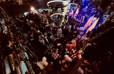 Een drukke menigte op een feest met ronde lichten.